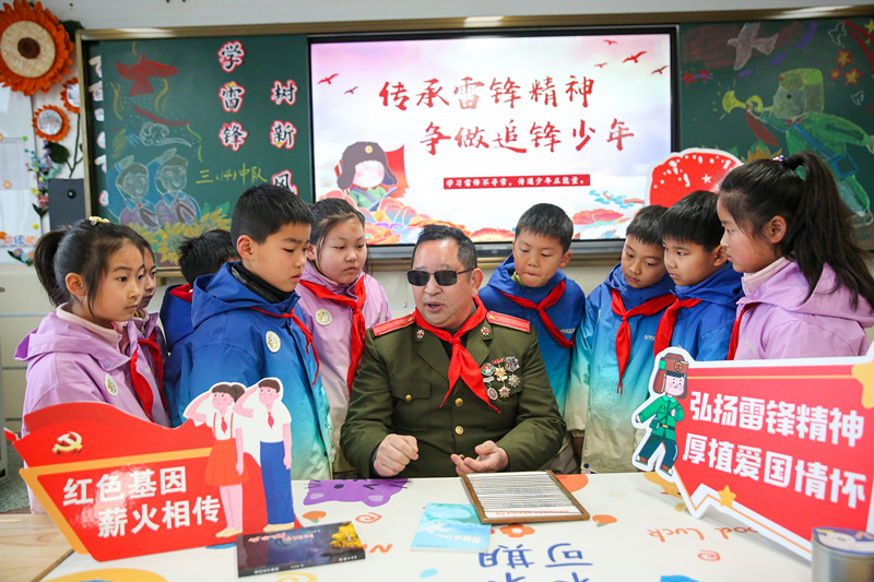 2025年3月3日，江蘇南通如皋市安定小學里，傷殘軍人許波銀在思政小課堂上向?qū)W生講述雷鋒故事。