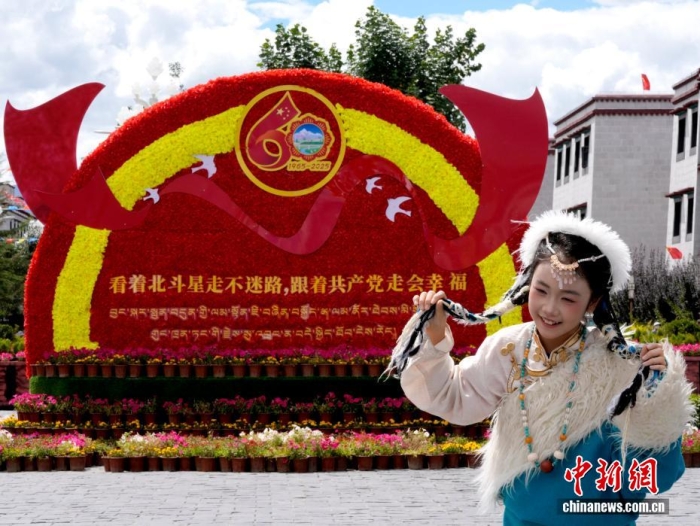 8月19日，隨著西藏自治區(qū)成立60周年慶祝活動臨近，拉薩氛圍濃。拉薩街頭，處處是張燈結(jié)彩的盛景，洋溢著一派祥和與歡騰的氛圍。圖為游客在拉薩大昭寺廣場上的大慶宣傳標(biāo)語前留念。<a target='_blank' href='/'>中新社</a>記者 李林 攝